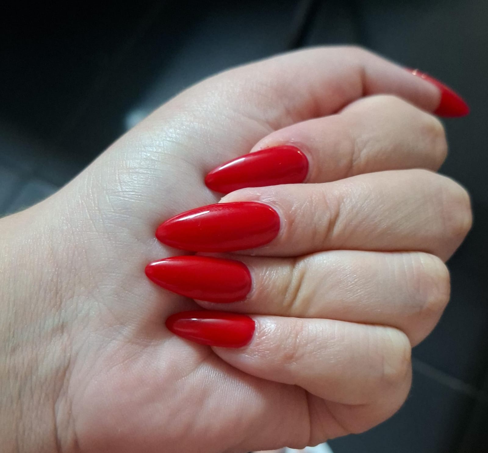 Glossy stiletto red gel nails by Cecily